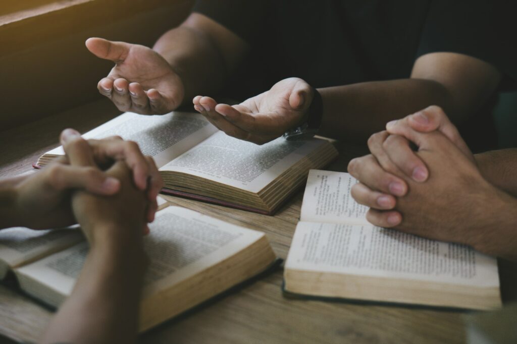 Group of christian people reading and study bible in home and pray together.