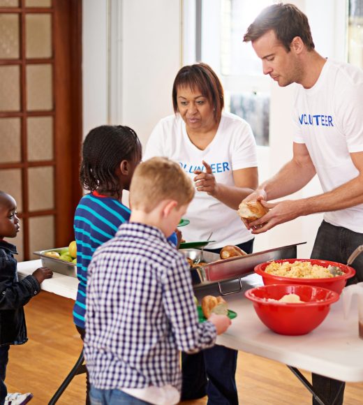 Theres plenty for everyone. Shot of volunteers serving food to a group of little children.